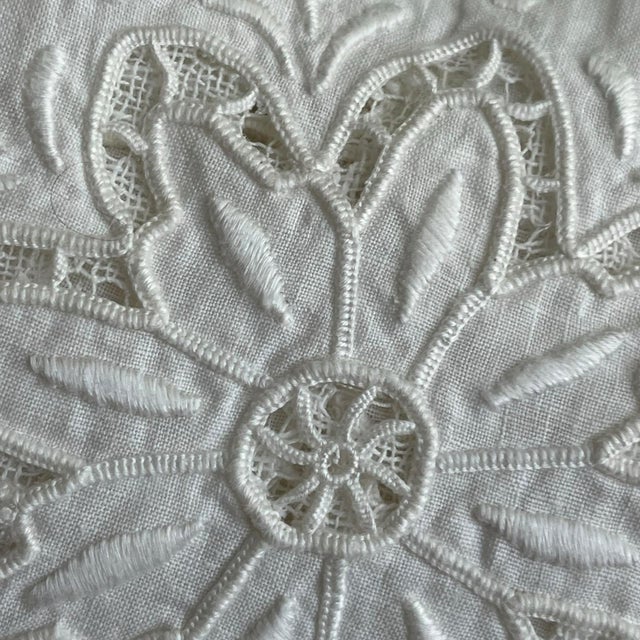 This is a vintage European tablecloth with stunning, elaborate white-on-white cutwork embroidery and needle or filet lace...