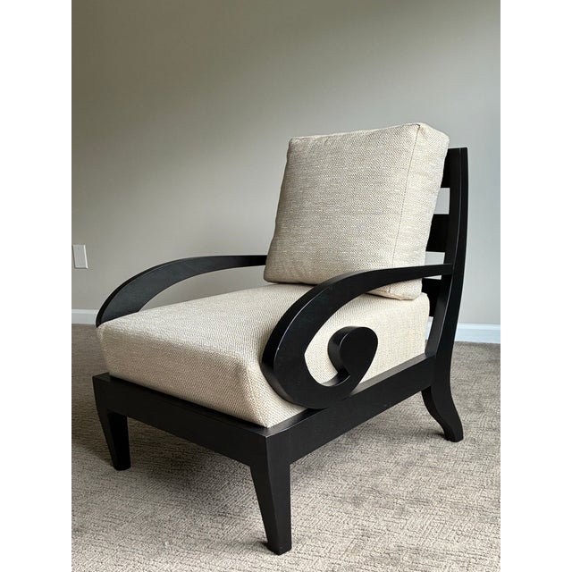 Elegant pair of contemporary lounge chairs featuring sculptural scroll arms in a rich ebonized wood finish and newly...