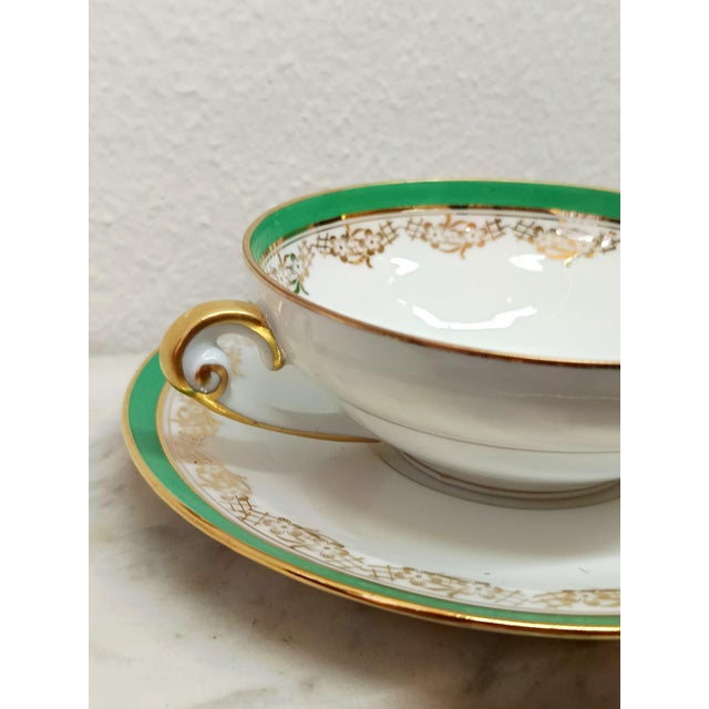 Twelve-piece Limoges porcelain tea set. Art Deco design by Georges Boyer, decorated with a green Empire border featuring...