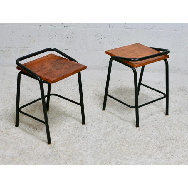 Pair of modernist stools, France, 1960s. Small marks and scratches on the wood (especially under the seat) and metal,...