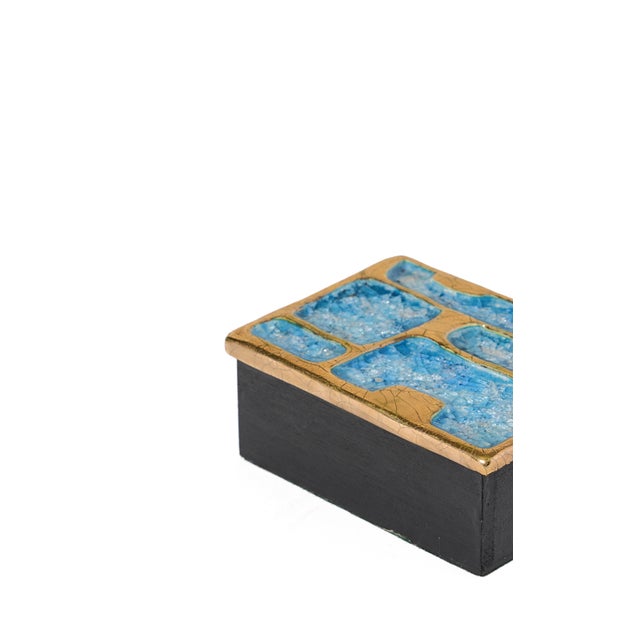 Black-painted wooden box with glazed ceramic top with crackled gold and precious blue and clear ceramic stone adornments....