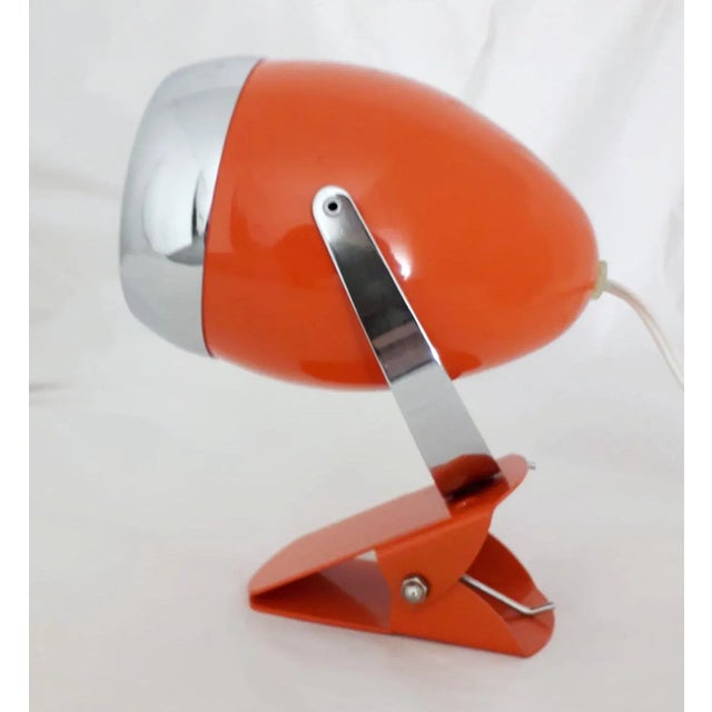 Vintage Italian adjustable spotlight with glossy orange enameled body and chrome hardware, mounted with simple clip base,...