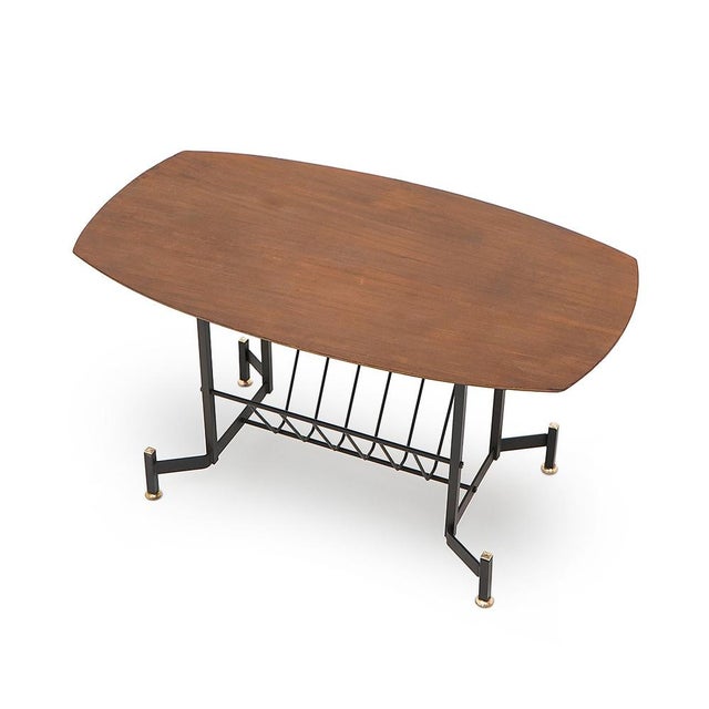 Italian-made coffee table produced in the 1950s. Structure in black painted metal. Teak veneered plywood top with tapered...