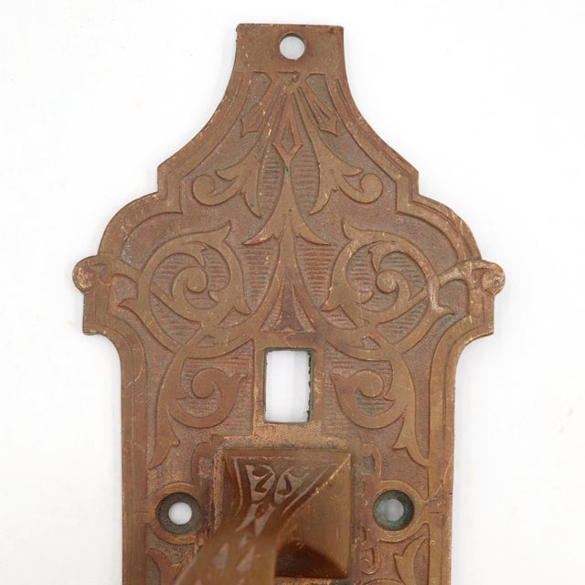 Antique door pull made of bronze with an ornate Victorian design and a missing thumb latch. The original mounting screws...