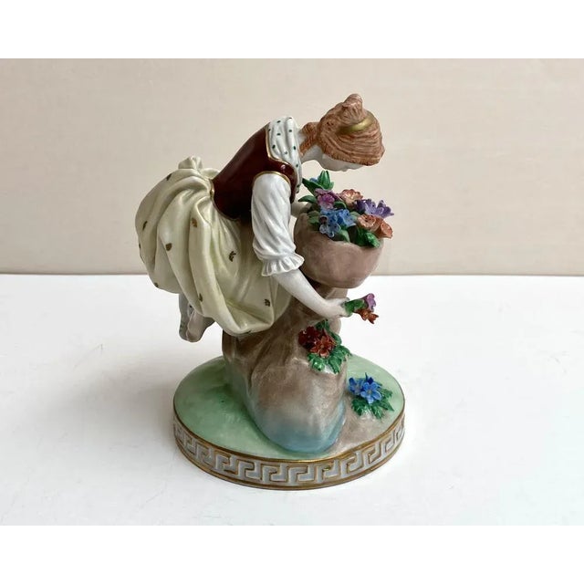 Porcelain hand painted figurine of a young girl with a bouquet of flowers. Skillfully traced details of clothing,...