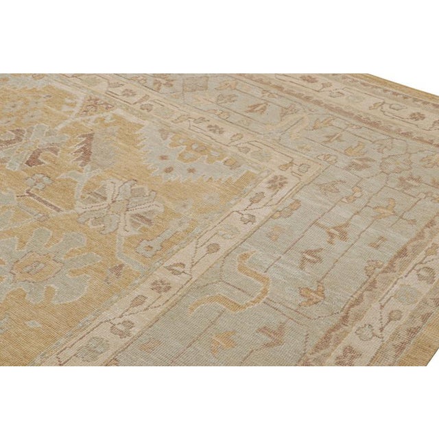 This 12x13 rug from the Modern Classics Collection features a gold field, blue and beige-brown borders underscore...