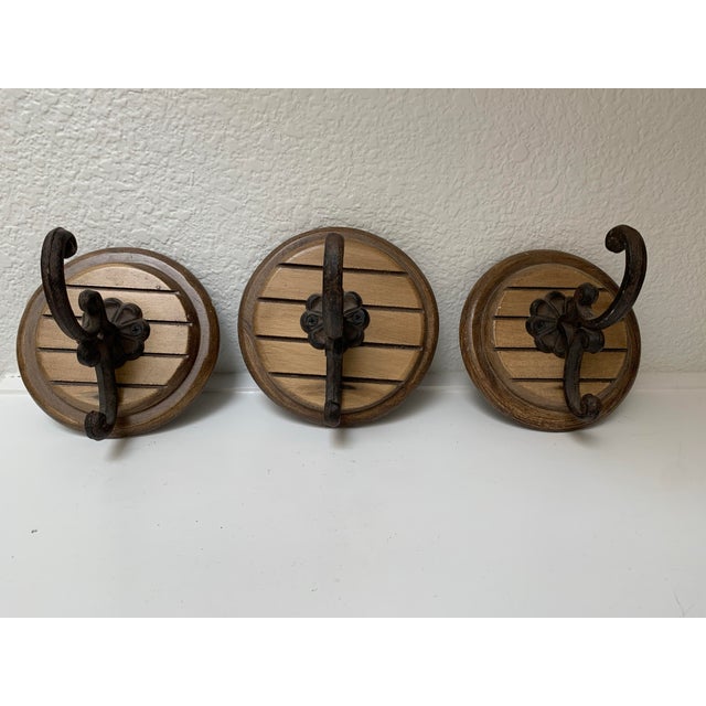 Rustic cabin style set of three earthy wall hooks with wood bare and iron hooks.