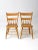 This delightful pair of antique primitive farmhouse chairs features warm, honey-toned wood, plank seats, and half-spindle...