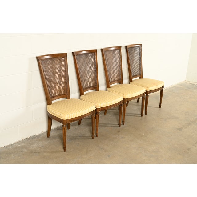 A gorgeous set of four French Regency Louis XVI style dining chairs By Henredon USA, Circa 1970s Carved solid walnut...
