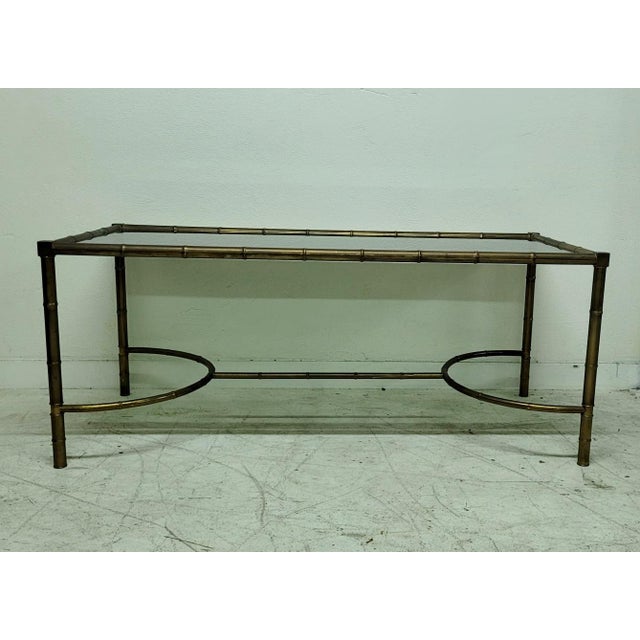 An elegant vintage coffee table dating back to the 1950s and 1960s, crafted from brass with a refined bamboo-effect finish...