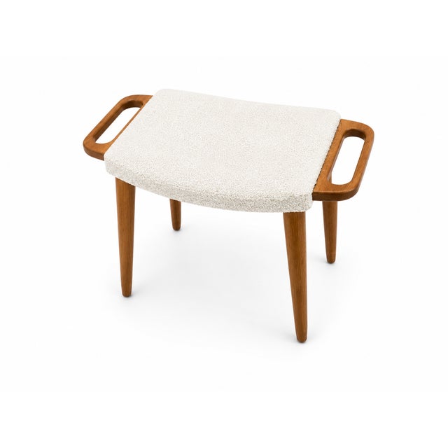 Mid century style modern solid oak stool. Upholstered in a white Boucle. The stool made in the manner of Hans J. Wegner...