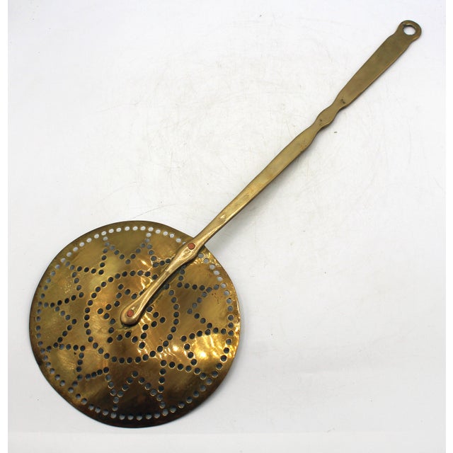 Circa 1860-80 English brass skimmer. Concentric circles & stars punch work motif. Brass rivets. Shaped handle. 21.75" x 7...