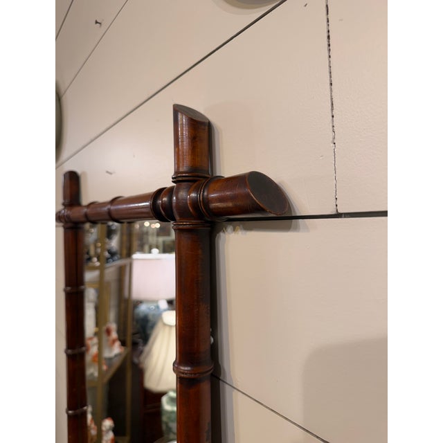 This is a French antique faux-bamboo wall mirror with a hand-carved wood frame. The frame is wood that has been shaped and...