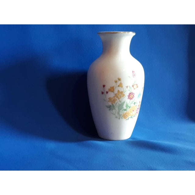 This lovely white vase with transferware of wild flowers vase is accented with a golden rim. The bottom is marked along...