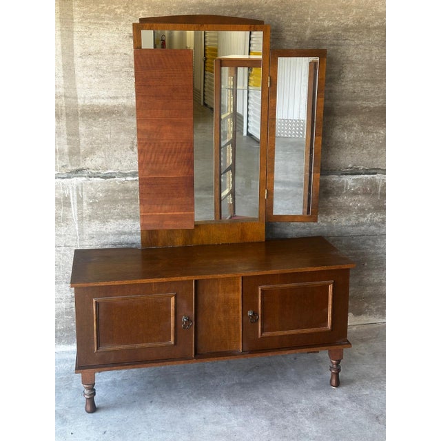 A vintage dressing table from the 1950s, characterized by its imposing triptych mirror and clean lines. The large central...