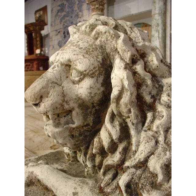 This is a 19th century French reconstituted stone lion statue lying down on a rectangular base. The sculptor who did the...