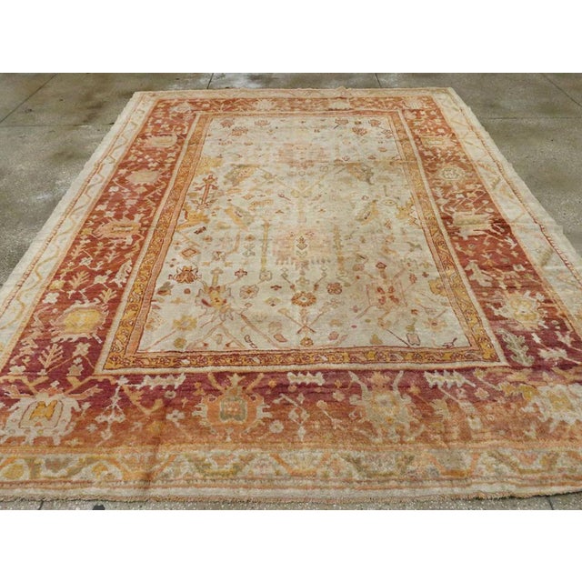 An antique Turkish Oushak room size carpet. This western Anatolian workshop carpet is patterned in a derivative Persian...
