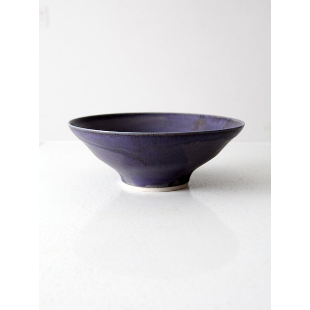 This vintage studio pottery bowl features a rich purple glaze and gently flared sides. Signed by the artist, the handmade...