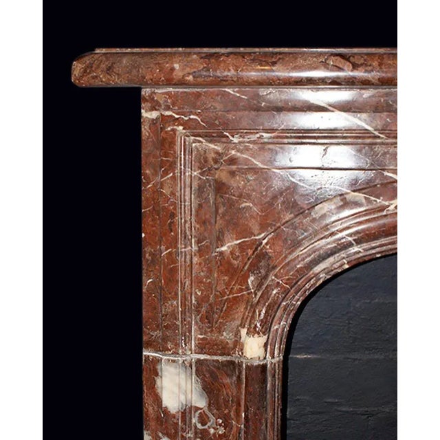 Striking c. 1870's French provincial style marble fireplace mantel in a beautifully veined red marble. Spandrel panels...