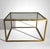 Refined and elegant Italian coffee table in brass with a smoked glass top. The linear and rigorous structure is crafted...
