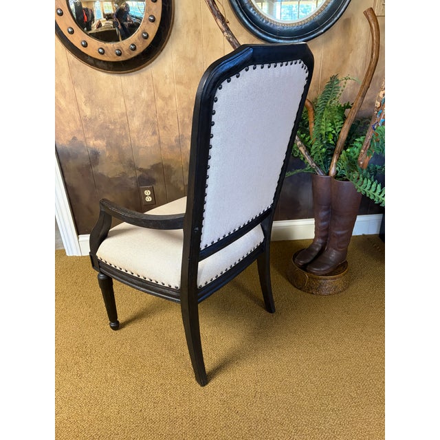 This handsome arm chair would be perfect at a desk, a table, or as an accent in any space. Wood frame finished in an ebony...