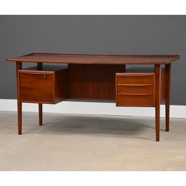 A mid century modern teak floating top desk designed by Peter Løvig Nielsen with a drawer with the capability for hanging...