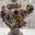 Dresden Porcelain in the Meissen style. A few small chips off flowers. One of cherub’s arm was glued back on and is...