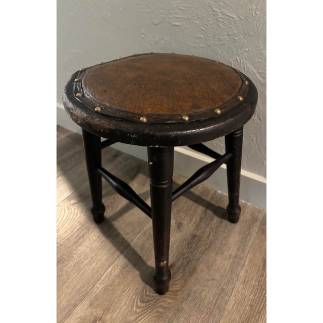 Rich in character and classic in form, this 19th century wood stool is topped with a beautifully worn leather seat, edged...