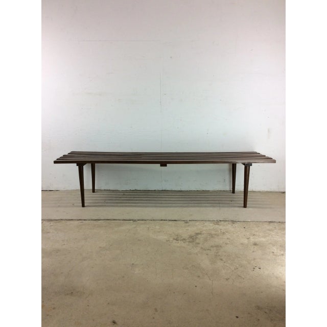 This mid century modern slat bench / coffee table features hardwood construction, original walnut finish, and tall tapered...