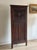 A tall Gothic Revival English oak corner cabinet, the full-height door carved with blind tracery around a crowned shield,...