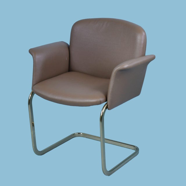 A pair of mid-century modern arm chairs with gleaming brass frames and classic period lines. Their sculptural presence and...