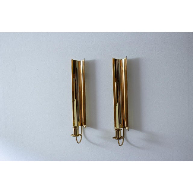 Pair of “Reflex” wall candlesticks designed by Pierre Forssell during the late 1960s. Manufactured by Skultuna in Sweden....