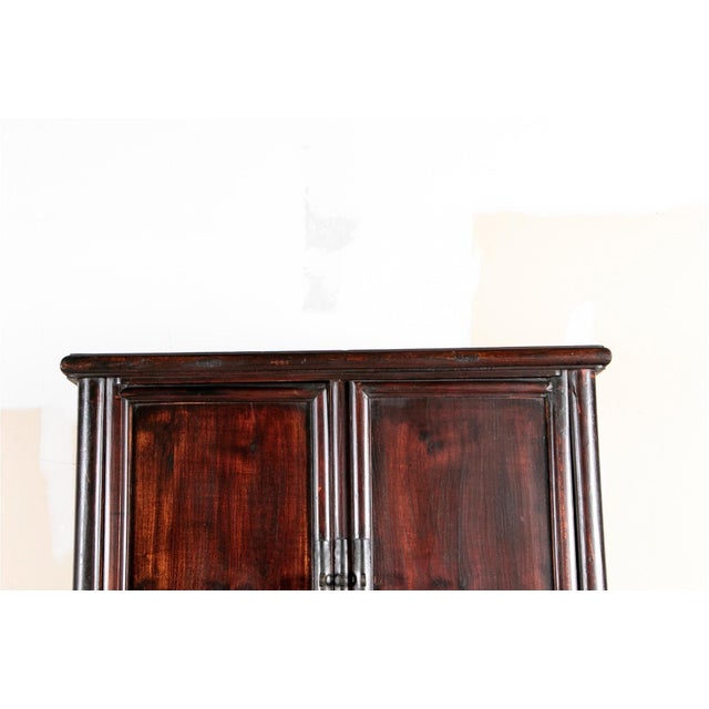 A tall, rectangular 19th century Chinese Ming style scholars storage cabinets with clean lines and framed panel...