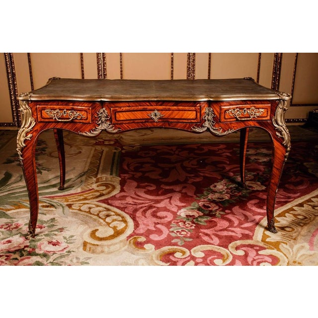 Bureau plat in the style of the Louis XV Napoleon III Paris, circa 1850-1880. In Bois-Satiné veneer, all-round full-length...