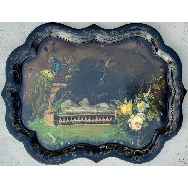 Painted tray table with hand-painted peacock and floral garden scene. Its scalloped top and substantial square legs create...