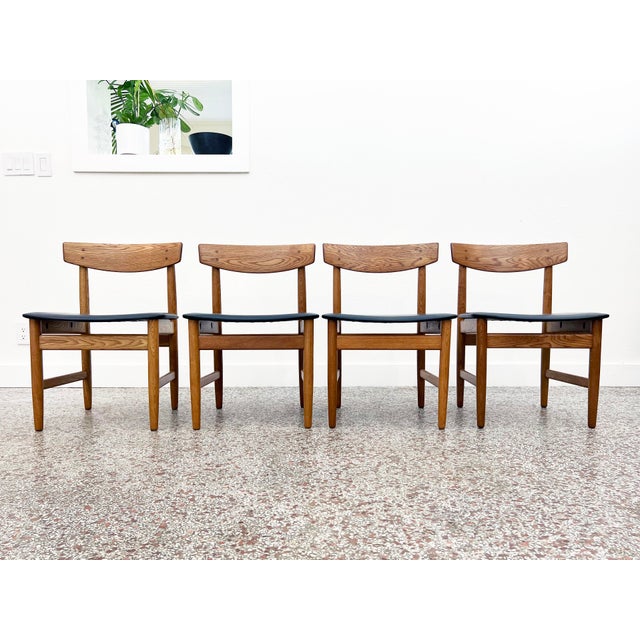 Set of four (4) vintage dining chairs in oak and black leather designed by Børge Mogensen for Karl Anderson and Söner....