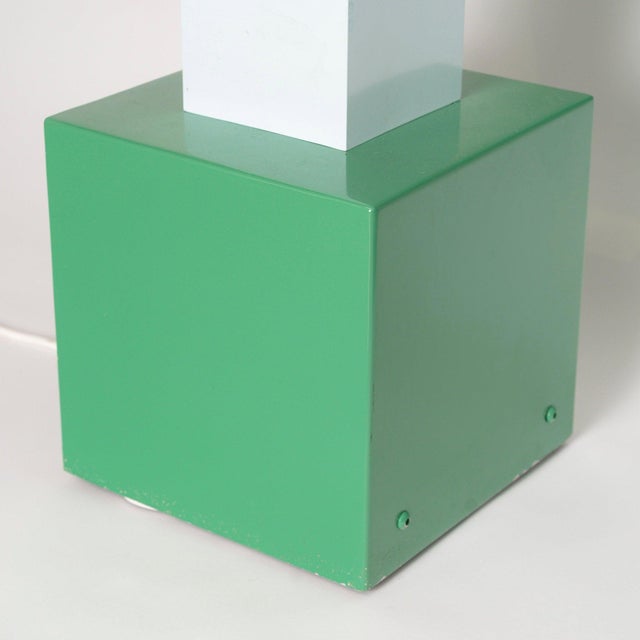 A column of stacked modules, alternately white and green, rests on a green base. Each module is a box open on one side,...