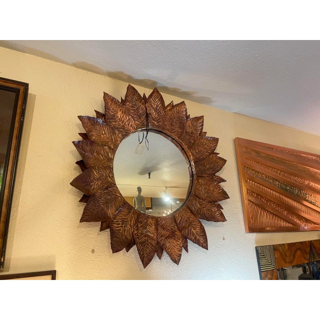 The Ben and Lael copper sunflower mirror is a unique and visually striking piece of home decor. The mirror's frame is...