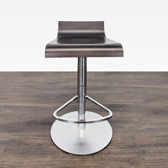 The Ligne Roset Pam bar stools are walnut stained oak and the base is chrome. The stool was designed by Claudio Dondoli...