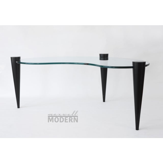 Incredibly cool MCM coffee table with a kidney-shaped glass top and black wooden cone legs. Each of the three detachable...