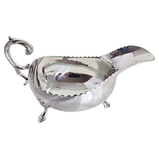 A fine Britannia Standard silver sauce or gravy boat dating to 1968, displaying elegant traditional craftsmanship and a...