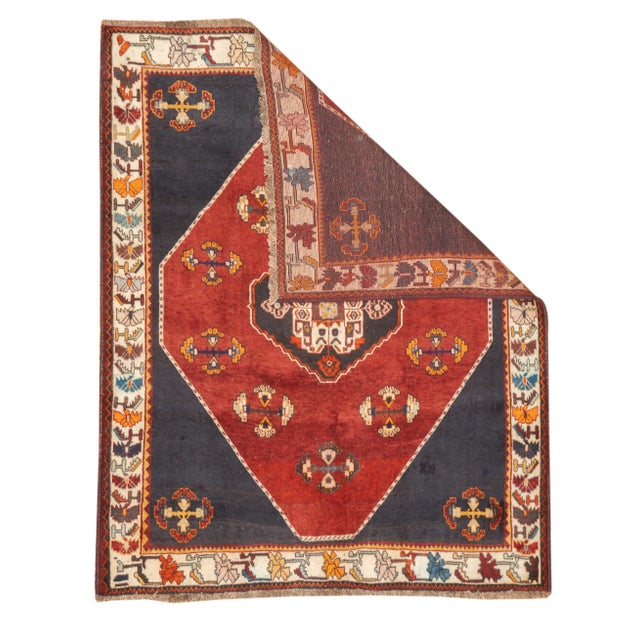 Semi-antique hand-knotted Persian Qashqai rug with a large stepped diamond medallion set within a dark field. The...