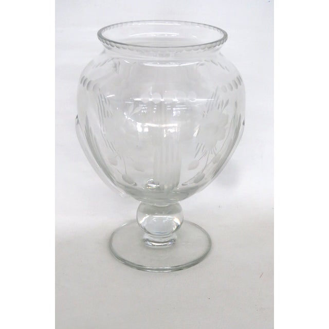 This stunning Pedestal Vase is made of glass. This gorgeous vase presents an elegantly etched floral and geometric pattern...