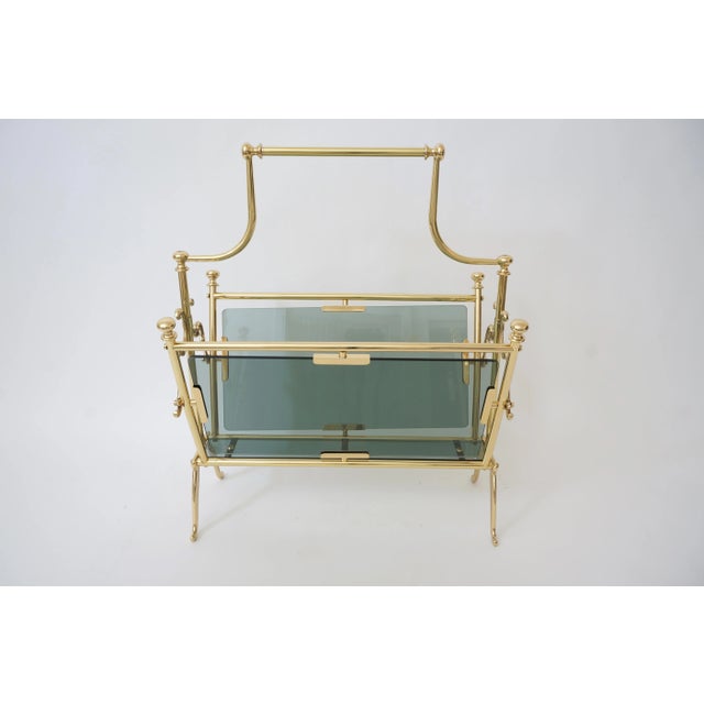 Mid-Century Maison Baguès Magazine Rack in Polished Brass and Blue-Gray Smoke Glass. Depending on the lighting and...