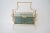 Mid-Century Maison Bagues Magazine Rack in Polished Brass and Blue-Gray Smoke Glass from a Palm Beach estate. Depending on...
