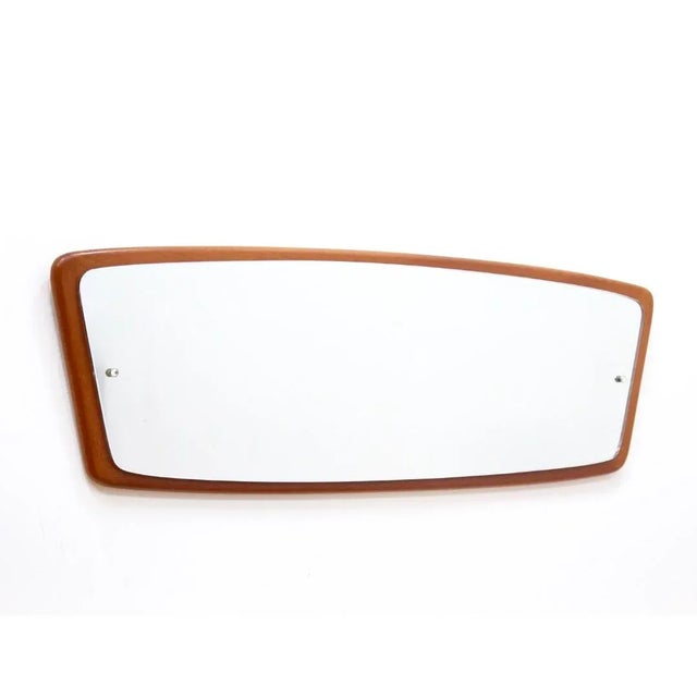 This mid-century wall mounted mirror was made in England during the 1960s. Produced in teak, the frame a has beautiful...
