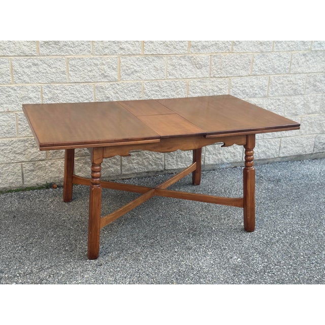 Solid wood construction with warm medium-tone finish. Dining table with turned legs and stretcher base, expands with a...