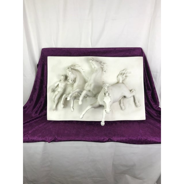 Exquisite three dimensional sculpture of Anahita's assistant attempting to reign in the wild horses. Three horses leap...