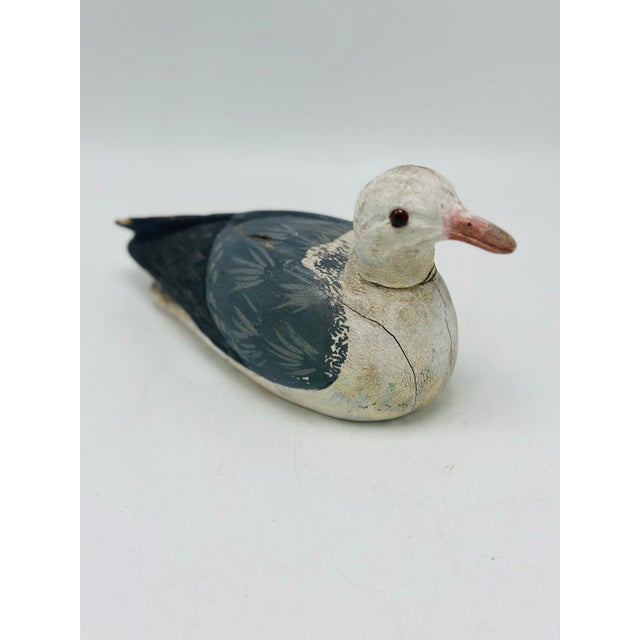 This is a vintage hand-carved wooden seagull figurine with a simple, folk art style. The bird is painted with a white head...