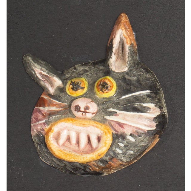 A 1970s ceramic tile by the American artist Mark Bulwinkle (born 1946). This ceramic piece depicts the face of a black cat...